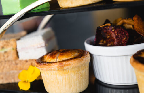 This luxury afternoon tea is served with an array of savouries including these warm pork pies & crisps.