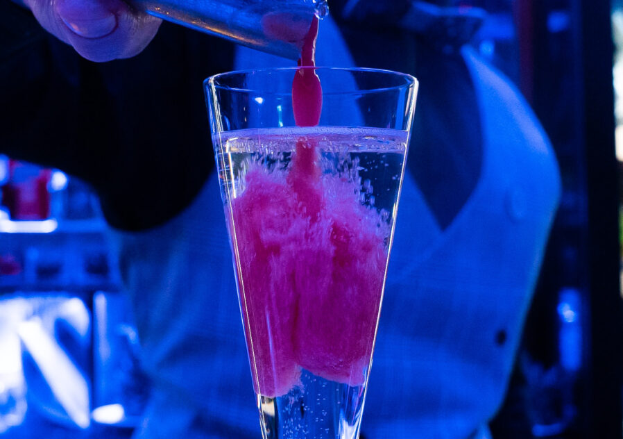 Bartender adds finishing touches to Raspberry Bellini cocktail mixture